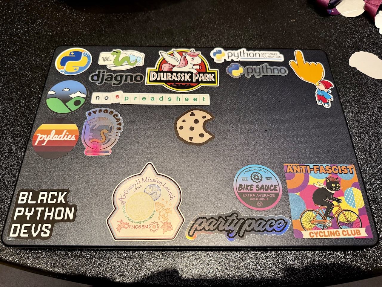 whole bunch of Python and cycling themed stickers on a laptop case