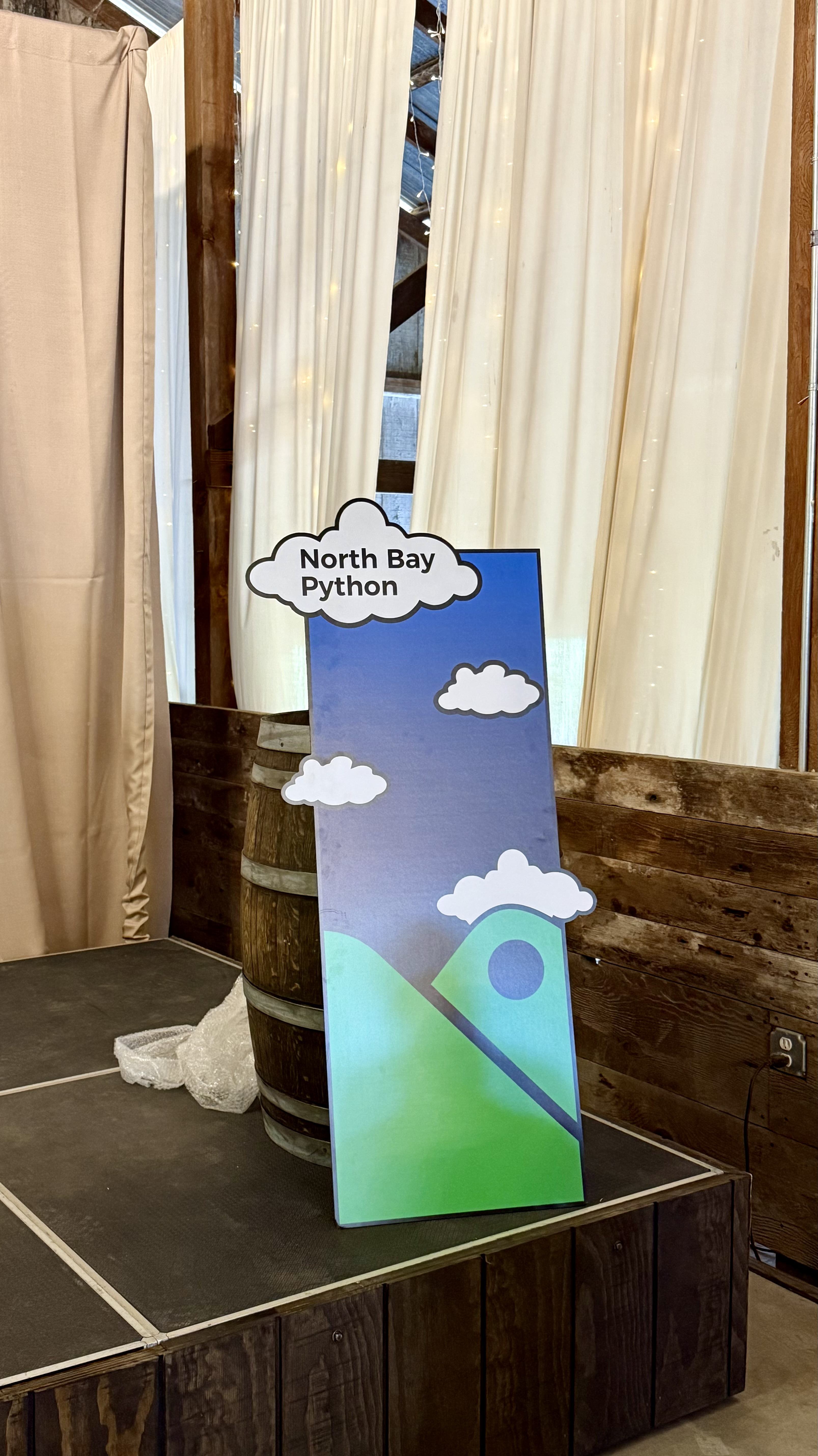 NBPy podium cover leaning on a barrel on the stage